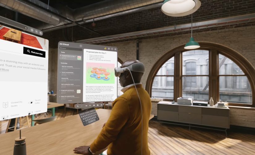 An image of a man using Apple Vision Pro headset to multitask. It's a conceptual image and shows what the user might be seeing: two open web browser floating in front of hi,