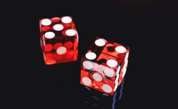 Red and white dice on a black backdrop