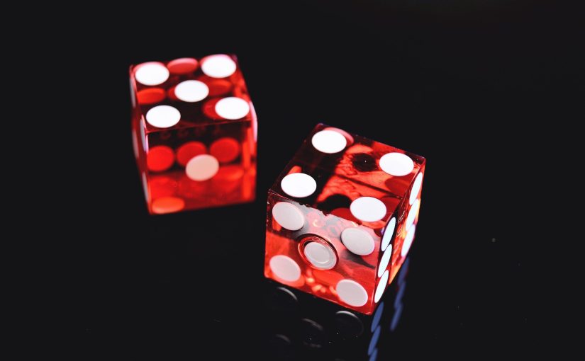 Red and white dice on a black backdrop